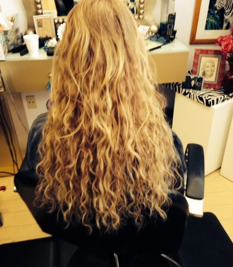 Long, blonde hair extensions by Pizzazz Beauty Salon.