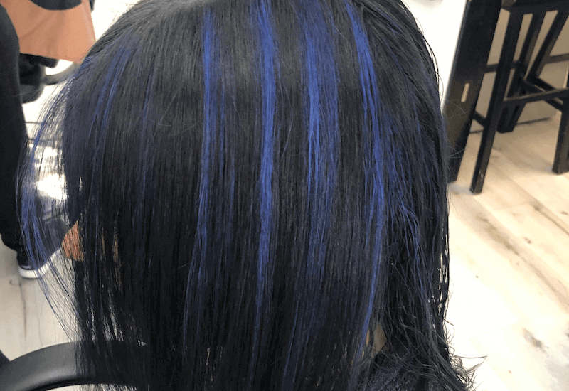 A girl with royal blue highlights on black hair.
